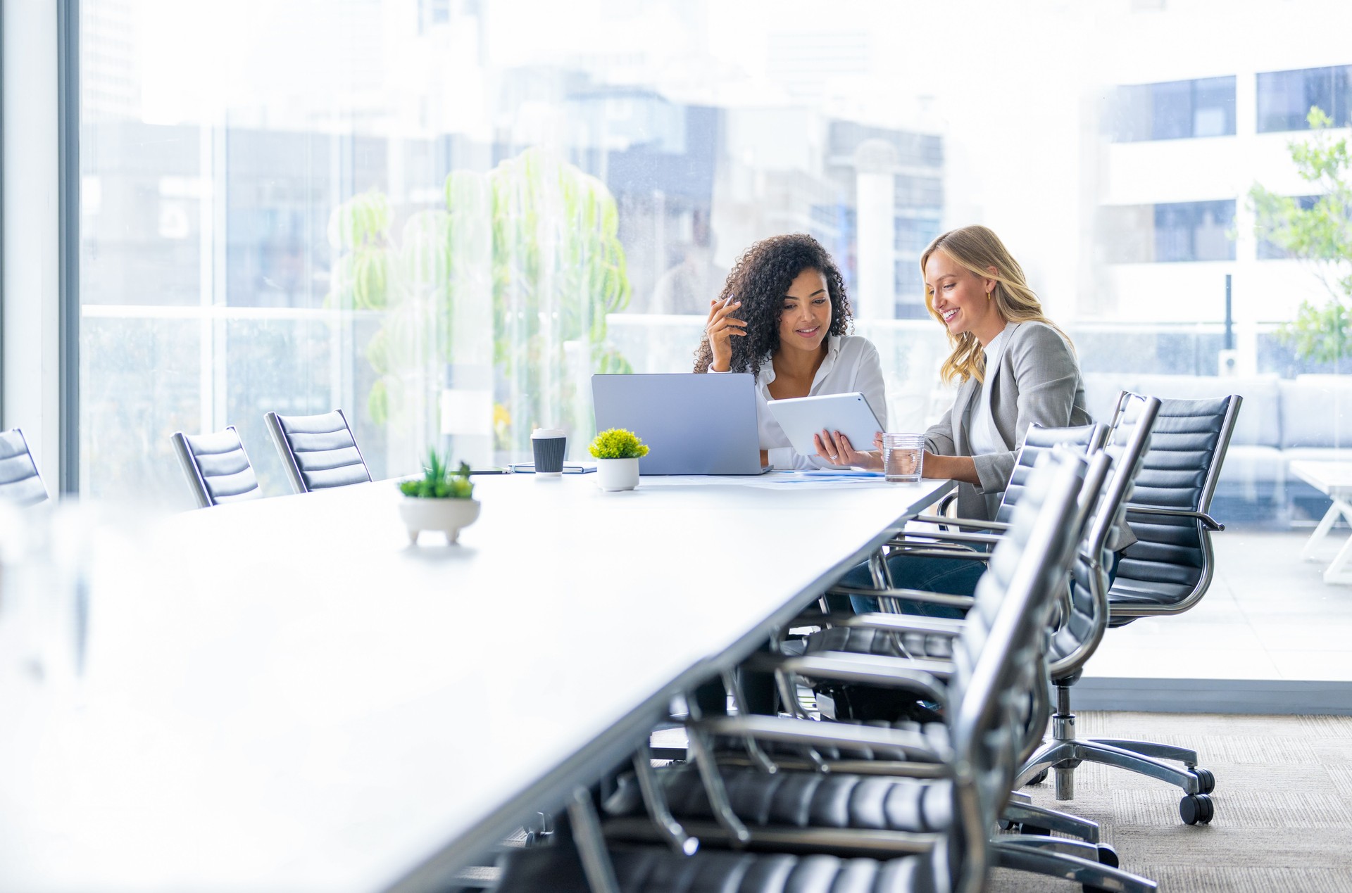 Business colleagues having a conversation in a board room. They are both young business people casually dressed in a modern office.